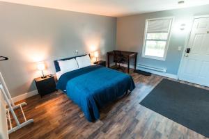 a bedroom with a bed and a desk and a window at Nest Inn in Watertown