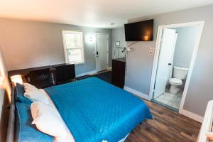 a bedroom with a blue bed and a bathroom at Nest Inn in Watertown