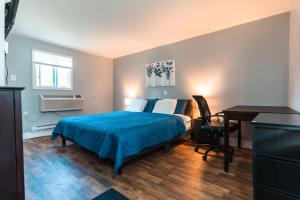 a bedroom with a bed and a desk in it at Nest Inn in Watertown +26 photos