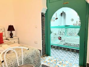 a bedroom with a green door with a mosaic floor at Riad Nostalgie of Tetouan in Tétouan