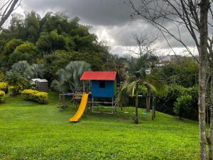 een speeltuin met een huis en een glijbaan bij Modern apartment surrounded by nature in La Tebaida