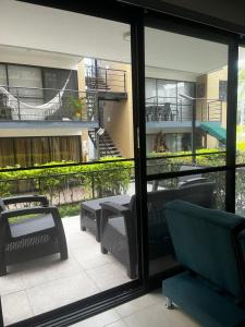 een patio met tafels en stoelen en een balkon bij Modern apartment surrounded by nature in La Tebaida