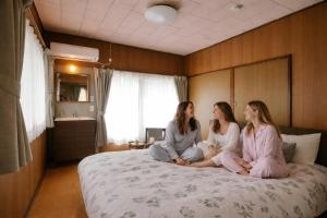 two women sitting on a bed in a bedroom at KAIUN海雲川越 kaiunkawagoe in Kawagoe +41 photos