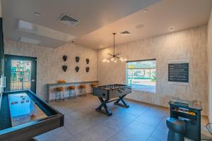 een speelkamer met een pingpongtafel en een pingpongbal bij Live by Stadium with BalconyPoolGymParkingWD in Shamrock Mobile Home Park