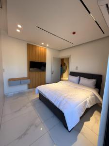 um quarto com uma cama grande com lençóis brancos em الكوت للأجنحة السكنية - Alkout Suites em Irbid