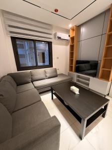 uma sala de estar com um sofá e uma mesa de centro em الكوت للأجنحة السكنية - Alkout Suites em Irbid mais 1 fotografia