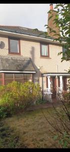 a brick house with windows and a yard at Cozy & Comfy Apartments Dundee in Dundee