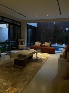 un soggiorno con un divano e un tavolo di شاليه لوسيندا a Baljurashi