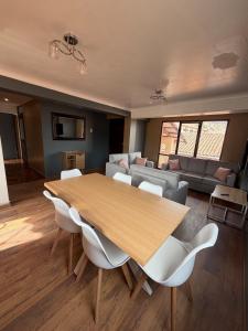 uma sala de estar com uma mesa de madeira e cadeiras brancas em Apartment in the center of Cusco em Cusco