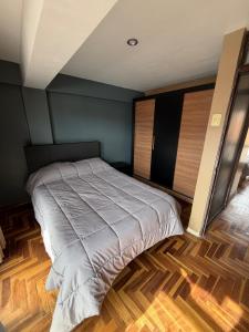 uma cama grande num quarto com pisos em madeira em Apartment in the center of Cusco em Cusco