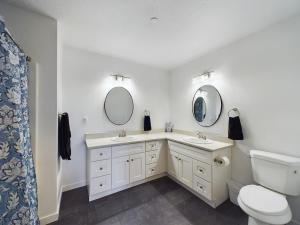 a bathroom with two sinks and a toilet and mirrors at SilverStrike Condos Family Friendly Walkable Location Unit 2 in Kellogg +31 photos