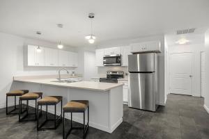 a kitchen with white cabinets and a stainless steel refrigerator at SilverStrike Condos Family Friendly Walkable Location Unit 2 in Kellogg