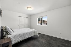 a white bedroom with a bed and a window at SilverStrike Condos Family Friendly Walkable Location Unit 2 in Kellogg
