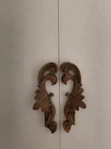 a pair of carved wood handles on a white wall at B&B Casa Diaz in Verona
