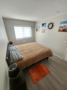 1 dormitorio con 1 cama grande y reloj en la pared en Departamento 2D y 2B Familiar, en Concepción 13 fotos más