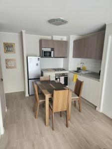 Una cocina con una mesa y sillas en una habitación. en Departamento 2D y 2B Familiar, en Concepción