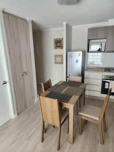 Una cocina con mesa de comedor y sillas. en Departamento 2D y 2B Familiar, en Concepción