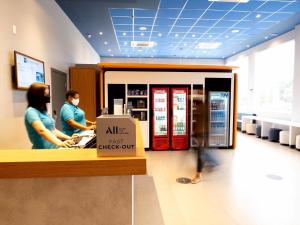 two people standing at a cash register in a store at ibis budget Leme SP in Leme
