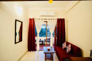 a living room with red curtains and a red couch at GVK Holiday Inn in Mysore