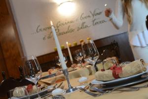 einen Tisch mit Kerzen und Weingläsern auf dem Tisch in der Unterkunft Hotel Margherita in San Martino di Castrozza