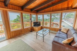 Arnold Beach House في روكواي بيتش: غرفة معيشة مع أريكة جلدية وطاولة زجاجية