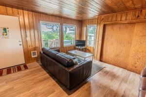 Arnold Beach House في روكواي بيتش: غرفة معيشة مع أريكة جلدية وطاولة