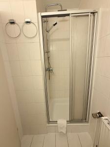 a shower with a glass door in a bathroom at Pension Bockenem GbR in Bockenem