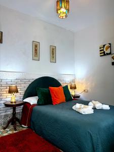 um quarto com uma cama verde e almofadas coloridas em Riad Nostalgie of Tetouan em Tetouan