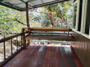 un porche con un banco en el lateral de una casa en The Big House บ้านพักริมเล, en Ranong