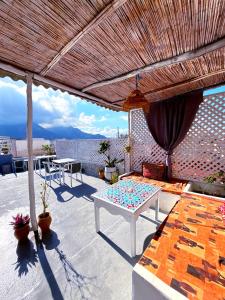 um pátio com uma mesa branca e um telhado de madeira em Riad Nostalgie of Tetouan em Tetouan mais 67 fotografias
