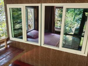 una habitación con 3 ventanas en una casa en The Big House บ้านพักริมเล, en Ranong