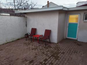 two red chairs and a table on a patio at Garsoniera 20m2 anexată la casa proprietarului in Botoşani +7 photos
