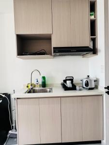Una cocina con gabinetes de madera y un fregadero. en ARC Towers Condominium, en Cebú