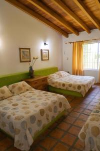 a bedroom with two beds and a window at Villa Vitali - Casa vacacional con Piscina y Jardines en Morrocoy para 14 personas in Tucacas +38 photos