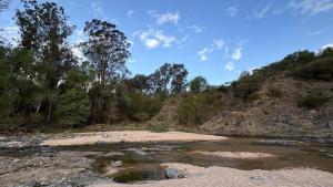 un fiume con rocce e alberi su una collina di Cabañas Yarel ad Alpa Corral Altre 13 foto