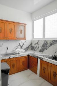 a kitchen with wooden cabinets and a sink and a window at Casal Apartment by REJA Essentials in Nusa Dua +60 photos