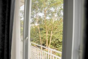 a window with a view of a tree at Casal Apartment by REJA Essentials in Nusa Dua