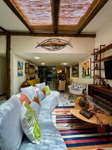 a living room with a blue couch and a piano at Refúgio Serra das Águas in Araras Petropolis