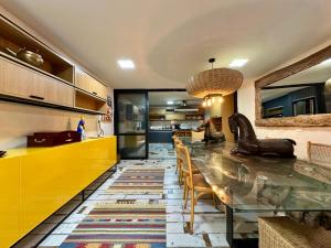 a kitchen with a dining table and yellow cabinets at Refúgio Serra das Águas in Araras Petropolis