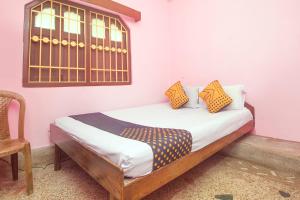 a bedroom with a bed with a window and a chair at Hotel O Greenwood in Rishop
