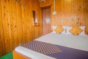 a bedroom with a bed in a wooden wall at Hotel O Greenwood in Rishop