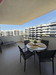 a balcony with two tables and chairs and buildings at Arenales SLB in Arenales del Sol