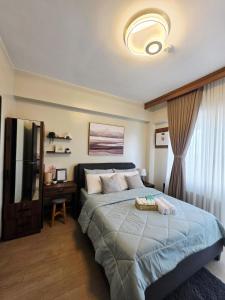 a bedroom with a large bed and a television at Two Regis Bacolod Cozy 1BR Condo with Balcony in Bacolod +10 photos