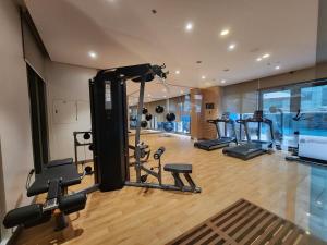 a gym with several tread machines in a room at Two Regis Bacolod Cozy 1BR Condo with Balcony in Bacolod