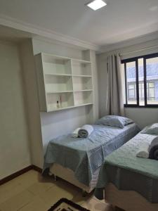 a bedroom with two twin beds and a window at Lar das Montanhas - 3 quartos até 8 pessoas in Marechal Floriano