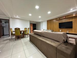 a living room with a large couch and a television at Lar das Montanhas - 3 quartos até 8 pessoas in Marechal Floriano