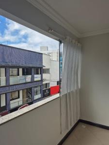 a room with a window with a view of a building at Lar das Montanhas - 3 quartos até 8 pessoas in Marechal Floriano