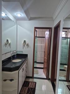 a bathroom with a sink and a shower with a door at Lar das Montanhas - 3 quartos até 8 pessoas in Marechal Floriano +31 photos