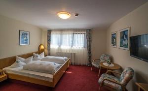 a hotel room with a bed and a television at Hotel Restaurant Freihof in Oberharmersbach +25 photos