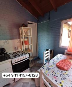 cocina con fogones y mesa. en Departamento Pinamar Ostende, en Ostende